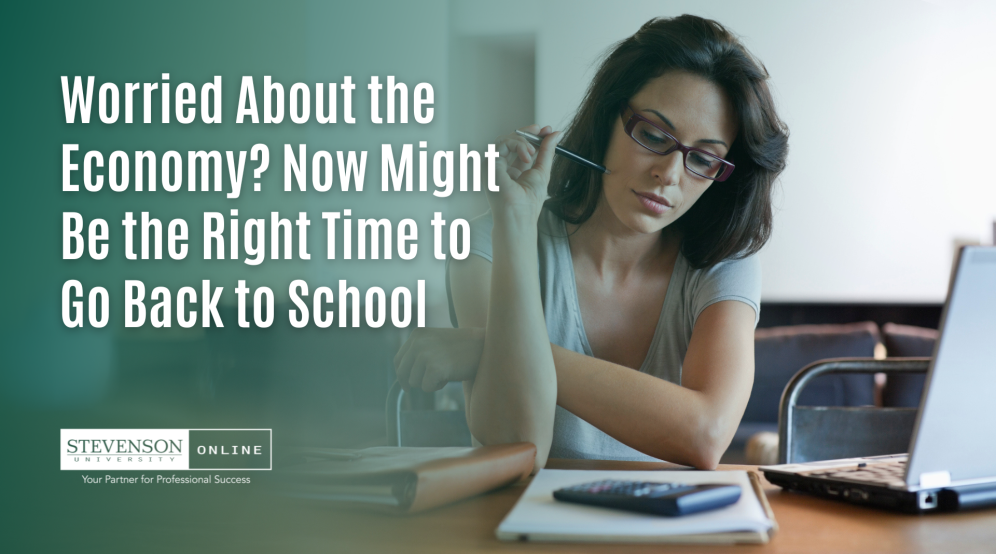Photo of woman with computer, notebook, and calculator with white text saying "Worried About the Economy? Now Might Be the Right Time to Go Back to School"